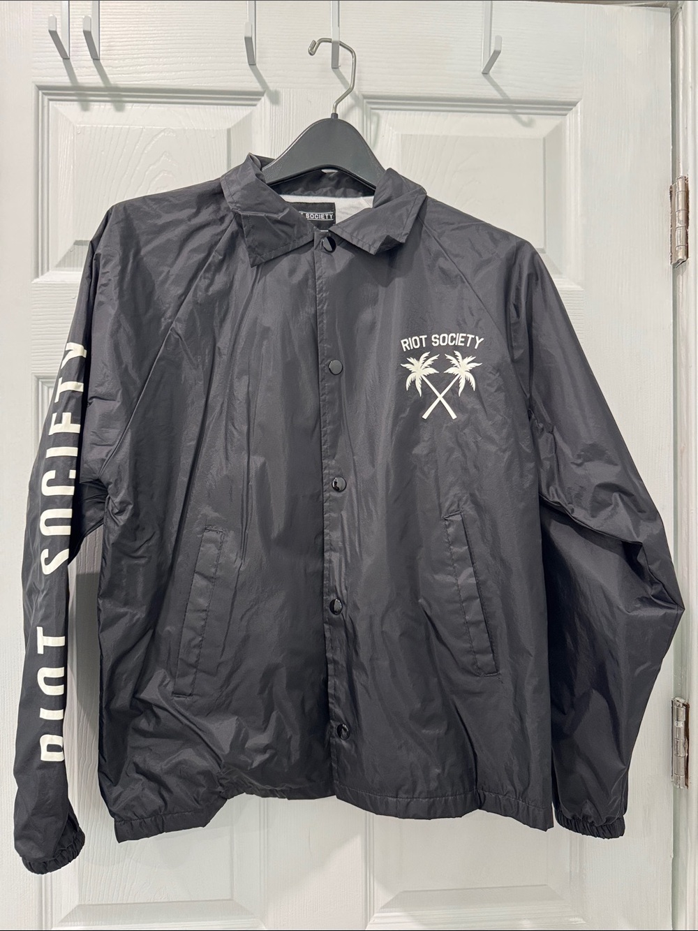 riot society black windbreaker with white palm logo